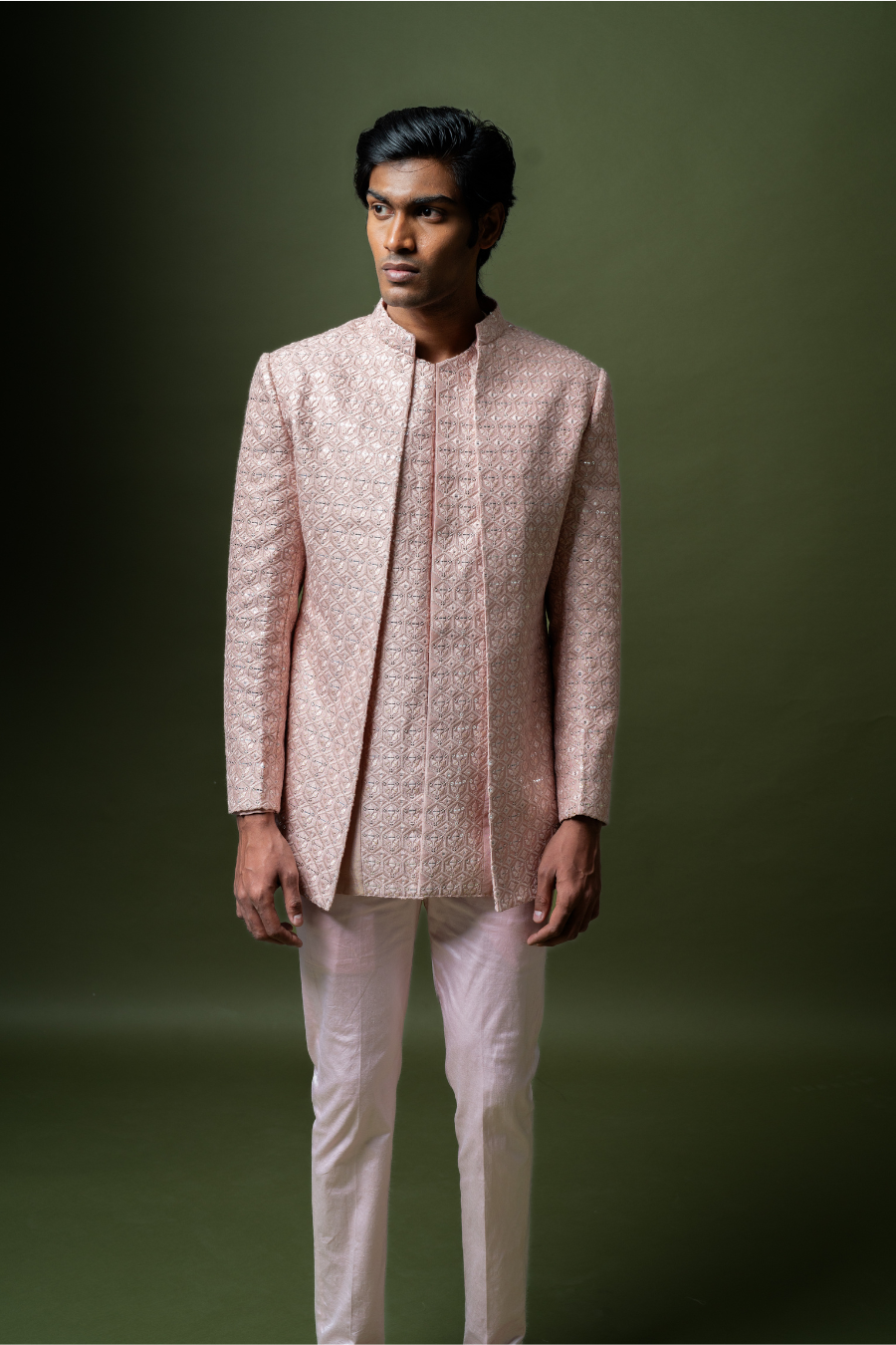 Traditional yet modern blush pink Jodhpuri suit worn by a male model for Indian wedding functions.