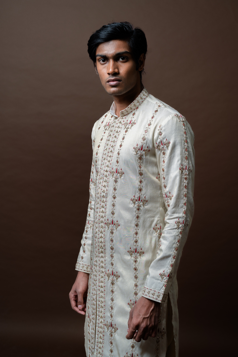 This hand-embroidered ivory kurta set offers a refined sherwani alternative for grooms seeking sophistication with a traditional twist.