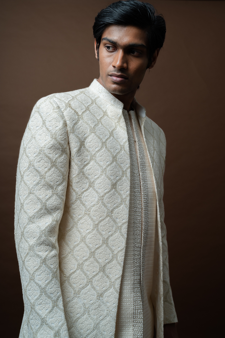 Groom dressed in ivory Jodhpuri set with subtle self-embroidery, suitable for traditional Telugu wedding rituals.