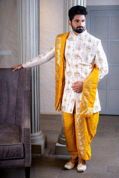 South Indian groom wearing a handcrafted white and mustard pattu sherwani with dhoti, perfect for Pellikoduku and Muhurtham functions in Hyderabad.