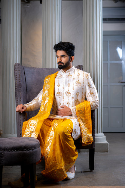 South Indian groom sitting in ivory and mustard pattu sherwani, perfect for wedding and Pellikoduku in Hyderabad