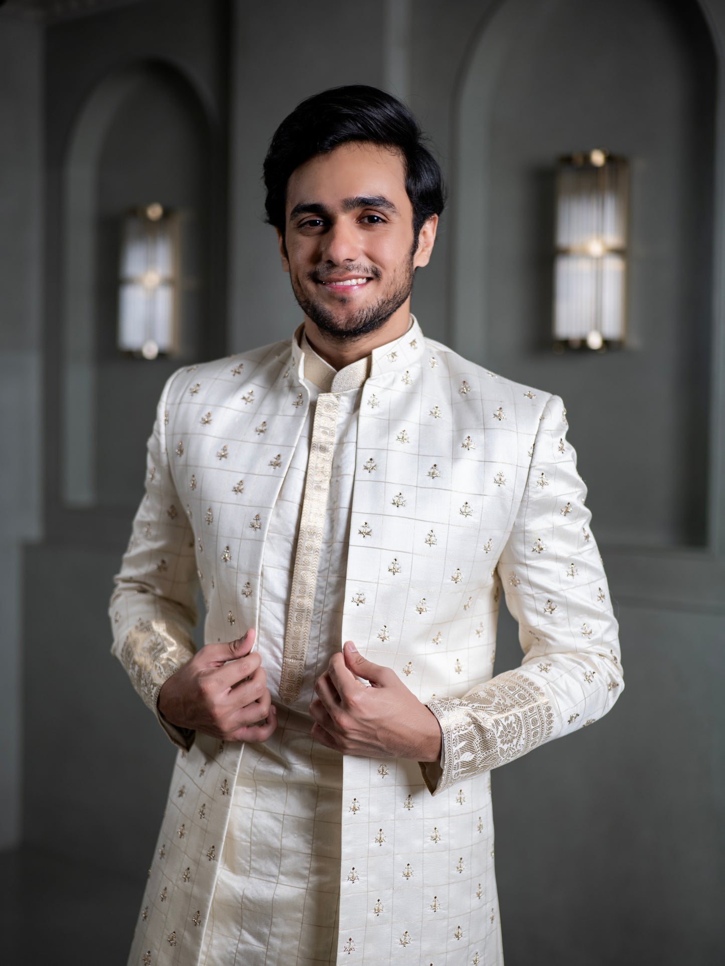 South Indian groom smiling in elegant ivory pattu sherwani with intricate embroidery for wedding in Hyderabad