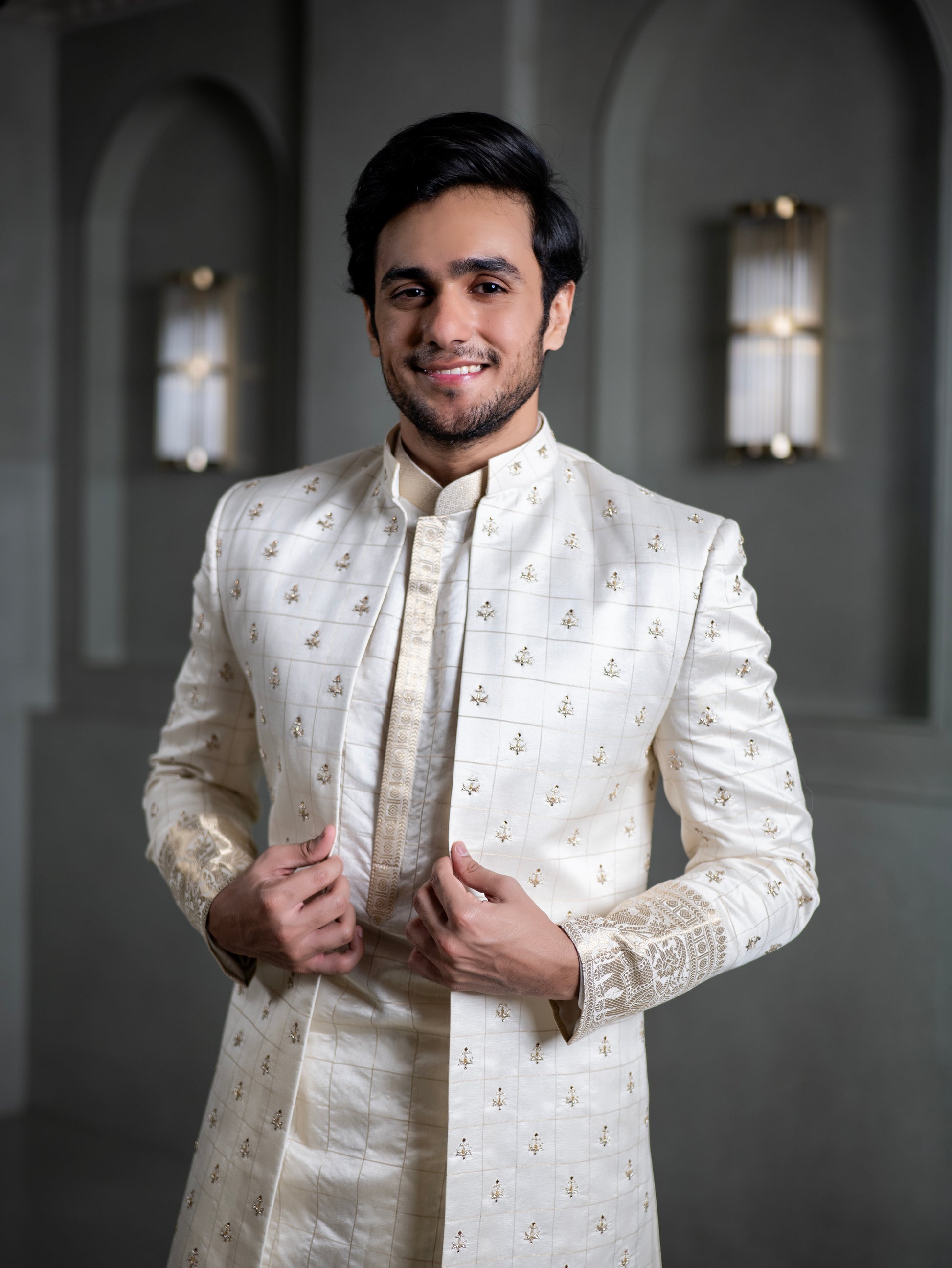 South Indian groom smiling in elegant ivory pattu sherwani with intricate embroidery for wedding in Hyderabad