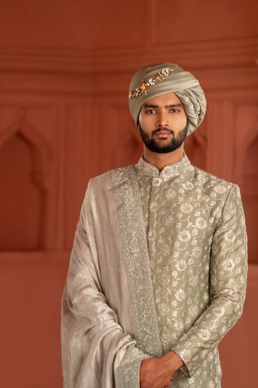South Indian groom dressed in pastel sage green hand-embroidered Pattu Sherwani with matching dupatta and turban, perfect for wedding, Muhurtham, and Pellikoduku in Hyderabad.

