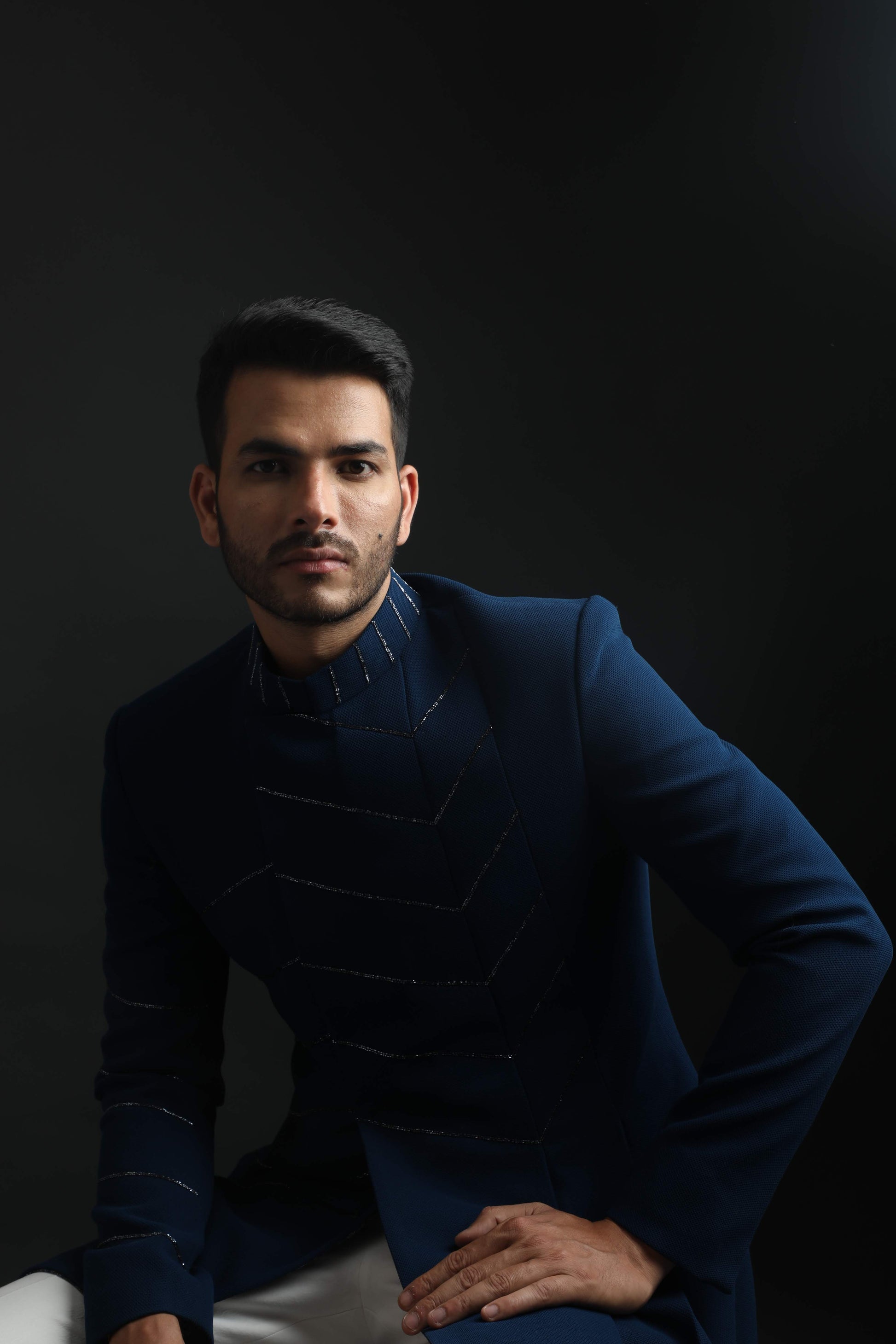 Groom in navy blue textured Indo-Western with subtle chevron embroidery, perfect for wedding reception or cocktail party in Hyderabad.

