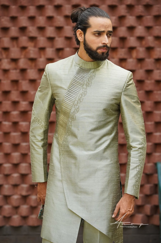 South‑Indian groom wearing a pista green hand‑embroidered Indo‑Western pattu sherwani at a Hyderabad wedding venue

